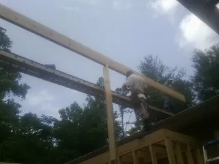 Carpenter setting a ridge beam over a new addition frame — Ice Dam Removal by Roofing Brothers in Miamitown