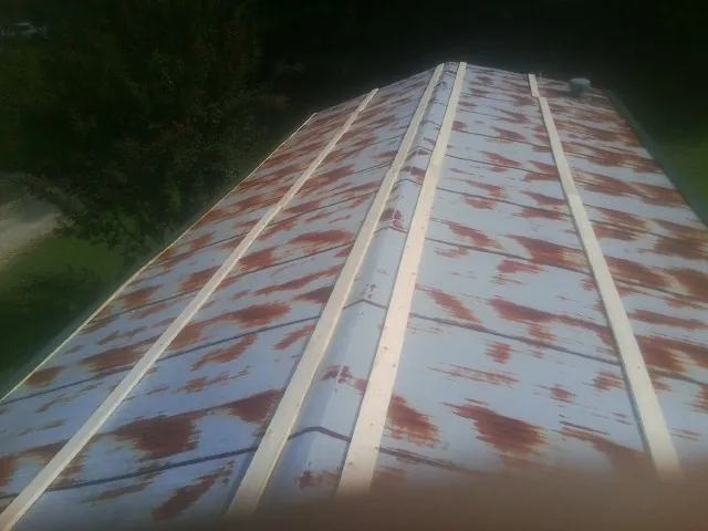 Rusted metal roof panels with new wood purlins before replacement — Storm Damage Roof Repair in Miamitown by Roofing Brothers
