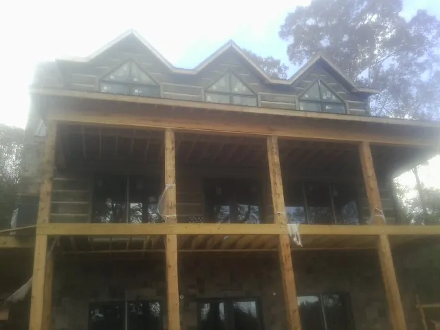 Dormers and porch framing on a large log home under construction — Roof Coating work by our crew in Miamitown