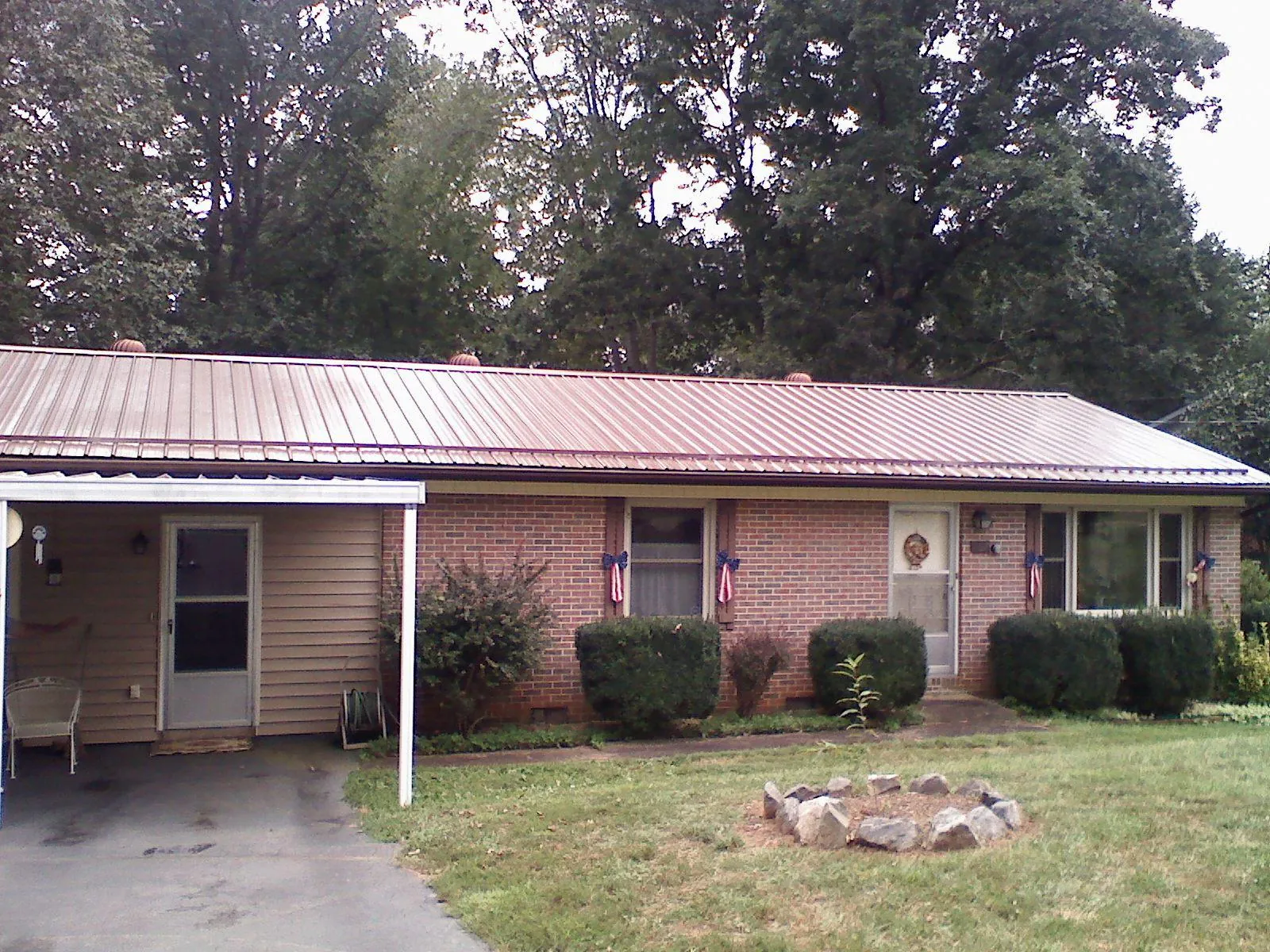 Bronze metal roof and carport on a brick ranch home — Roof Repair work by our crew in Miamitown